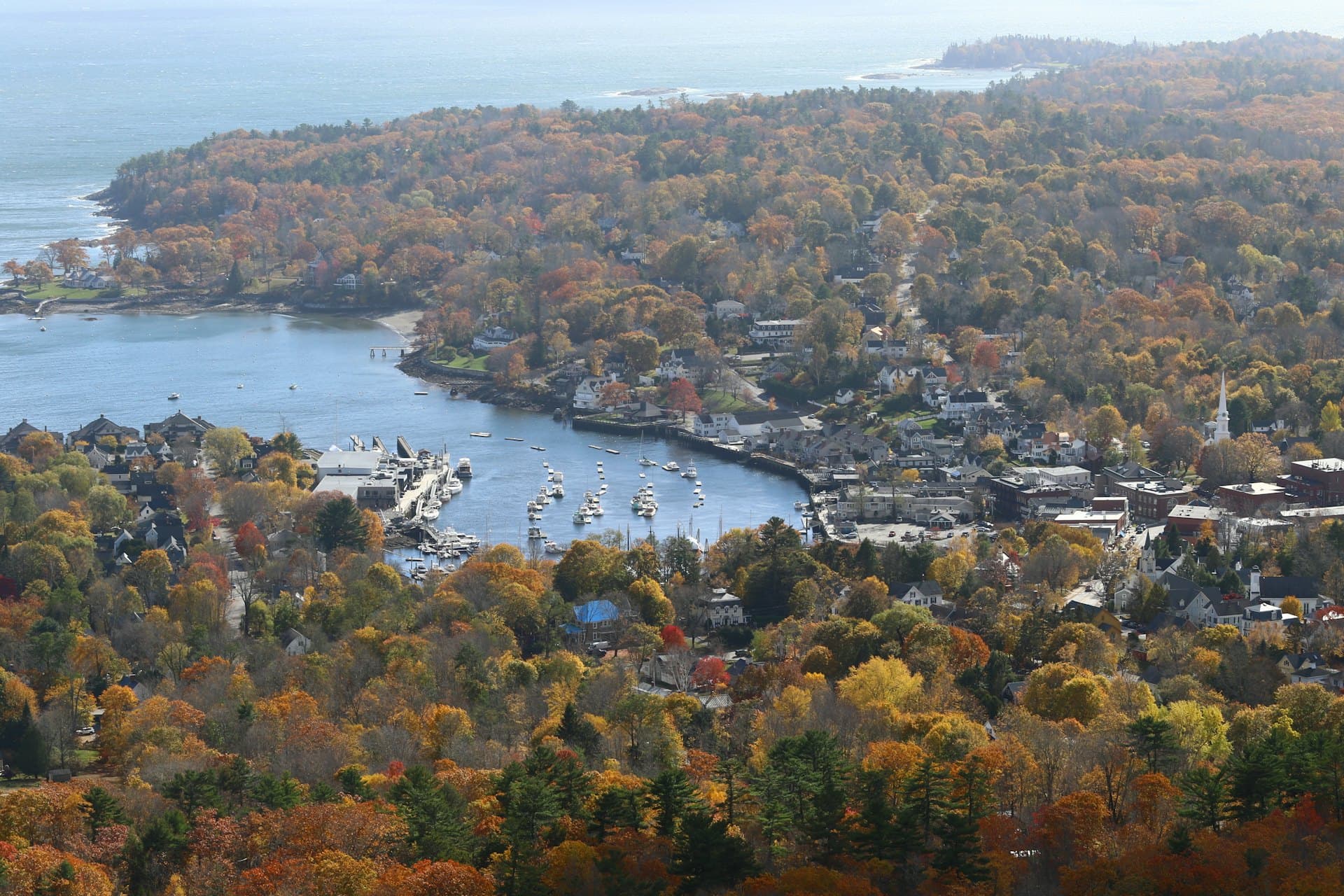 A New England harbour town in autumn, boats moored along the inner harbour