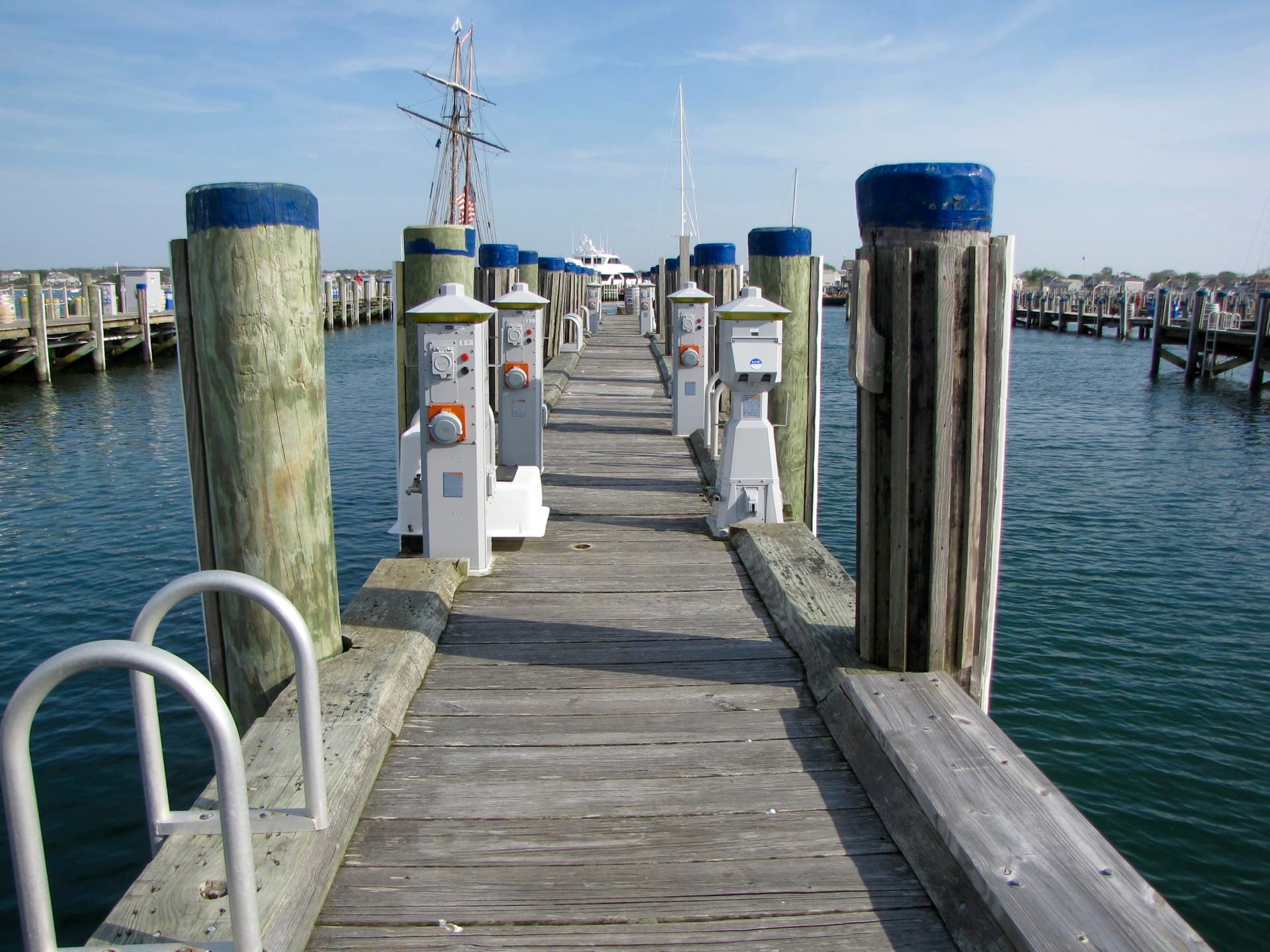 A wooden finger pier running out between its pilings to the boats at the end